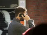 Un hombre habla con su teléfono móvil.