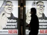 Un hombre pasa por delante de un cartel que pide el "no" en el referéndum suizo sobre las armas en Berna, Suiza.