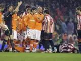 Los jugadores del Athletic de Bilbao y del Valencia rodean a Fernando Llorente (d) y David Navarro (i), ambos en el suelo.