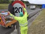 Un operario retira una pegatina que indica el l&iacute;mite de velocidad de 110 kil&oacute;metros por hora en la autov&iacute;a que une Vitoria y Bilbao.