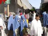 Fotografía tomada el pasado mes de julio en Kabul, en la que varias mujeres, vestidas con el tradicional burka azul, pasean por las calles de un mercado de la zona vieja de la capital afgana.
