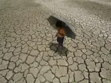 Un niño indio camina por un terreno agrietado, en el pasado una charca, debido a la fuerte sequía, en Bhubaneswar, Orissa, India.