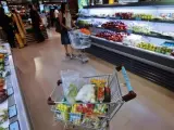 Imagen de un carrito lleno de productos en un supermercado.