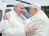 El papa emérito Benedicto XVI y el papa Francisco se abrazan tras la llegada de este último al helipuerto de Castel Gandolfo. Benedicto XVI renunció a su pontificado el 28 de febrero "por falta de fuerzas". El adiós de Benedicto es la primera renuncia papal por voluntad propia desde 1294.