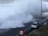 Una ola de grandes dimensiones se adentra en la carretera de acceso a la localidad pontevedresa de Baiona, fruto del temporal de viento que azota el litoral gallego.