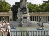 Dos personas se fotograf&iacute;an junto al estanque del parque madrile&ntilde;o de El Retiro.