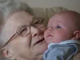 Una abuela levanta en brazos a su nieto.