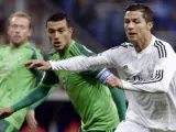 El delantero portugués del Real Madrid Cristiano Ronaldo (d) con el balón ante el defensa argentino del Celta de Vigo Gustavo Cabral (i).