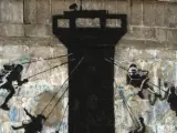 Columpios girando en torno a una torre militar de vigilancia. Obra de Banksy en Gaza