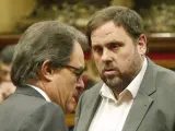 El presidente de la Generalitat, Artur Mas, y el líder de ERC, Oriol Junqueras, conversan en el hemiciclo del Parlamento catalán.