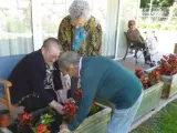 Tres ancianos plantan flores en una residencia para la tercera edad de Cataluña.
