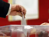 Un ciudadano ejerce su derecho al voto introduciendo el sobre con su papeleta en una de las urnas.