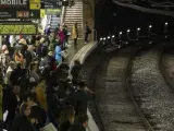Usuarios del Metro de Barcelona esperan en el andén de la estación de Plaza España.