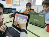 Unos ni&ntilde;os utilizan ordenadores port&aacute;tiles en el aula.