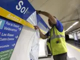 Un trabajador coloca la nueva señalización de la estación de metro de Sol, tras finalizar el patrocinio de Vodafone.
