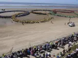 Un gran n&uacute;mero de personas forman los aros ol&iacute;mpicos mientras la antorcha ol&iacute;mpica pasa por la playa Crosby de Liverpool, Inglaterra.