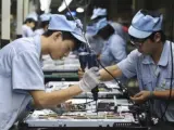 Varios operarios chinas trabajan en una línea de montaje en una fábrica de Shenyang, en la provincia de Liaoning (China).