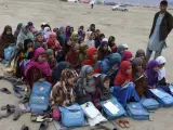 Refugiados afganos asisten a un colegio al aire libre, fuera de sus refugios temporales en la provincia de Laghman, en Afganistán.