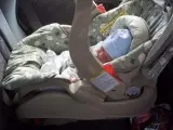 Un bebé, en el asiento trasero de un automóvil.