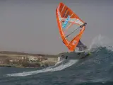 Uno de los participantes en el Campeonato Mundial de Windsurf en Tenerife 2017 cogiendo una ola.