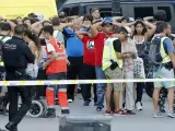 Un grupo de gente con los brazos en alto ante el despliegue policial en el lugar del atentado ocurrido en las Ramblas de Barcelona.