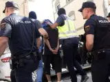 Efectivos de la Policía Nacional traslada a un detenido en el marco de una operación antiterrorista en Melilla.