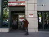 Un hombre sale y otro entra a una oficina de empleo de Madrid.