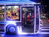 Un conductor vestido de Papá Noel conduce un autobús de la alcaldía de Sao Paulo decorado con luces de Navidad.