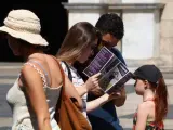 Imagen de un grupo de turistas mirando un follet&iacute;n en la plaza Sant Jaume de Barcelona.