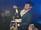 Un hombre intenta abrir una gran botella de champ&aacute;n, valorada en 34.400 euros, en un local de Ibiza.