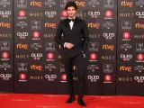 El actor Quim Gutiérrez posa, con un elegante esmoquin de Dsquared2 y una pulsera de platino de los años 20, a su llegada a la alfombra roja de los Premios Goya 2018.