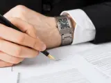 Un hombre firma un contrato en una oficina.