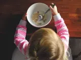 Una ni&ntilde;a desayunando cereales.