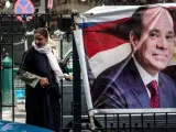 Una mujer camina junto a un cartel con la imagen del actual presidente egipcio y candidato presidencial, Abdelfatah al Sisi, en El Cairo.