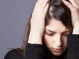 Una mujer afectada por un dolor de cabeza.