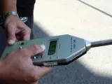 Un agente de la Guardia Urbana midiendo el ruido con un sonómetro.