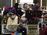 Numerosos pasajeros esperan en los mostradores de Iberia en el aeropuerto de Barajas, durante la primera de las cinco jornadas de huelga de los trabajadores.