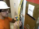 Un electricista revisando los cables de una instalación.