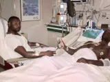 Eric Abidal en la cama del hospital junto a su primo .