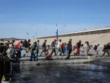 Un grupo de personas tratan de cruzar la garita El Chaparral, de la ciudad de Tijuana, en el estado de Baja California (México).