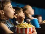 Niños comiendo palomitas en el cine