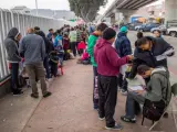 Un grupo de migrantes esperan para iniciar la solicitud de visa humanitaria.