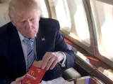 Trump comiendo una hamburguesa.