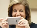 La exministra Fátima Báñez hace una fotografía con su iPhone a los periodistas en el Congreso de los Diputados.