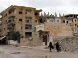 Dos mujeres caminan con un ni&ntilde;o junto a casas derruidas en Al Raqa, ciudad que fue la capital de facto de Estado Isl&aacute;mico en Siria hasta la expulsi&oacute;n de los yihadistas.