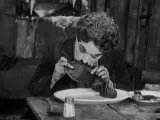 Chaplin en una de las escenas más recordadas de 'La quimera del oro', comiéndose una de sus botas.