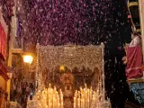 El paso de la Virgen de Nuestra Señora de la Esperanza bajo una lluvia de pétalos arrojados desde los balcones de la calle Pureza en el sevillano barrio de Triana durante su recorrido procesional en la Madrugá de Sevilla.