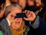 Para observar un eclipse hace falta un lugar con buena visibilidad, que no haya nubes y, sobre todo, proteger los ojos con una gafas o cristales adecuados que bloqueen la luz ultravioleta e infrarroja. Quedan descartadas opciones como varias gafas de sol tradicionales superpuestas, radiografías o vidrios quemados. En la imagen, una mujer mira el eclipse parcial en Porto Alegre (Brasil).