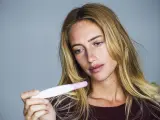 Imagen de una mujer consultando un test de embarazo.