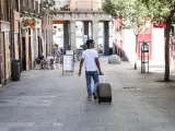 Imagen de recurso de un turista que pasea con una maleta por el centro de Madrid.
